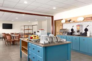 科尔尼科尔尼乡村酒店及套房的厨房配有蓝色橱柜和一张带一碗水果的桌子