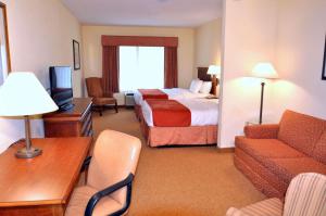 乔治湖Country Inn & Suites by Radisson, Lake George Queensbury, NY的酒店客房,配有床和沙发