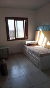 卡庞达卡诺阿Casa de Veraneio的卧室配有床,位于带2个窗户的房间