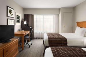 哥伦布哥伦布机场江山旅馆的酒店客房设有两张床、一张桌子和一台电视。