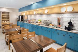 哥伦布哥伦布机场江山旅馆的餐厅设有蓝色橱柜和木桌