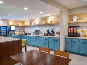 莫米莫米托莱多乡村套房酒店的厨房配有蓝色橱柜和桌椅