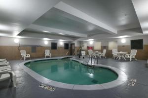 俄克拉何马城俄克拉荷马城机场卡尔森江山旅馆及套房酒店的一个带桌椅的大型游泳池
