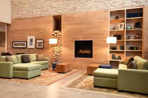 EnidCountry Inn & Suites by Radisson, Enid, OK的带沙发和壁炉的客厅
