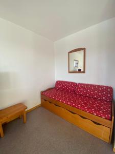 德沃吕伊Cozy apartment with views of the slopes的一间卧室配有红色的床和镜子