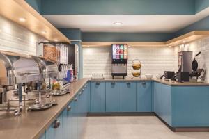 伊利Country Inn & Suites by Radisson, Erie, PA的厨房配有蓝色橱柜和台面
