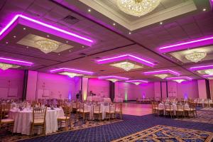 特里沃斯费城东北拉迪森酒店的宴会厅配有桌椅和紫色照明