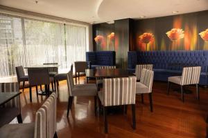 利马Radisson Hotel Decapolis Miraflores的餐厅设有1间带桌椅的用餐室