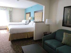 默特尔比奇Country Inn & Suites by Radisson, Murrells Inlet, SC的酒店客房,设有两张床和一张沙发