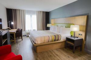 默特尔比奇默特尔比奇江山旅馆的酒店客房配有一张床、一张桌子和一把椅子。