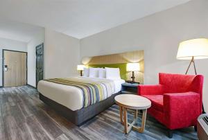 皮埃尔皮埃尔伊克诺旅馆酒店及会议中心的酒店客房,配有一张床和一张红色椅子