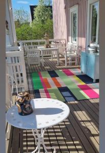 皮耶克赛迈基Wanha Neuvola Guesthouse & Apartment的一个带桌椅和彩色地毯的甲板