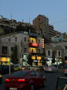 安曼Roman Theater Hotel的一条繁忙的城市街道,有汽车和建筑