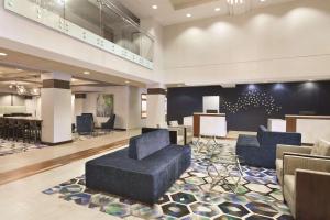 艾迪生达拉斯北艾迪生丽筠酒店的大楼内带蓝色沙发和椅子的大堂