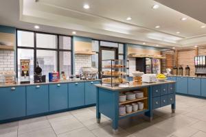 休斯顿德克萨斯州休斯顿西北部卡尔森乡村酒店及套房的厨房配有蓝色橱柜和食品柜台。
