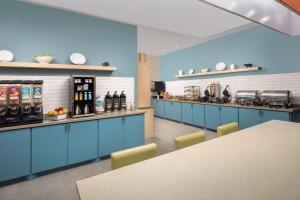 亨博尔卡尔森休斯敦洲际机场南乡村旅馆及套房酒店的厨房配有蓝色橱柜和台面
