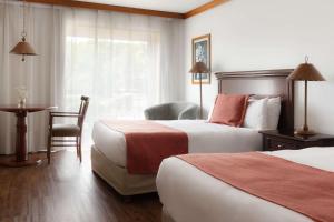 科洛尼亚-德尔萨克拉门托Radisson Hotel Colonia del Sacramento的酒店客房设有两张床和一张桌子。