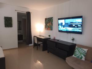 里奥阿托Playa Blanca Panama的客厅配有桌子和墙上的电视