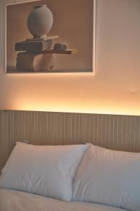 束草市UH FLAT The Sokcho的一张带白色枕头的床和墙上的照片