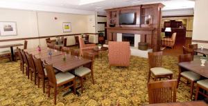 弗雷德里克斯堡Country Inn & Suites by Radisson, Fredericksburg, VA的一间带桌椅和壁炉的用餐室