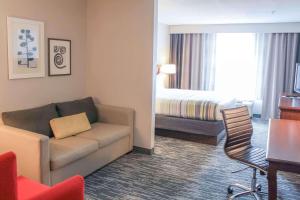 斯特灵卡尔森华盛顿杜勒斯机场江山旅馆&套房的酒店客房设有一张沙发和一张床