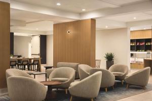 西塔科西雅图机场丽筠酒店的一间设有桌椅的等候室和一间酒吧