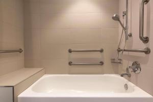 西塔科西雅图机场丽筠酒店的带淋浴的浴室配有白色浴缸。