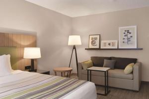 博瑟尔Country Inn & Suites by Radisson, Seattle-Bothell, WA的酒店客房,配有床和沙发
