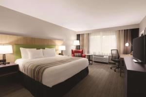 博瑟尔Country Inn & Suites by Radisson, Seattle-Bothell, WA的酒店客房设有一张大床和一张书桌。