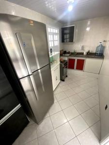 萨尔瓦多Casa em Praia do Flamengo - Salvador的厨房配有不锈钢冰箱和白色瓷砖地板。