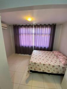 萨尔瓦多Casa em Praia do Flamengo - Salvador的卧室在窗户前配有一张床