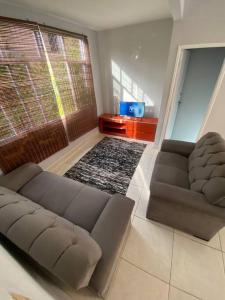 萨尔瓦多Casa em Praia do Flamengo - Salvador的带沙发和大窗户的客厅