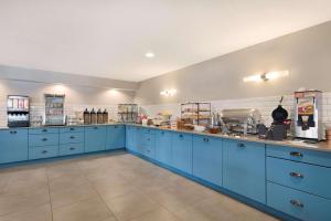 奇珀瓦福尔斯Country Inn & Suites by Radisson, Chippewa Falls, WI的一间设有蓝色橱柜和电器的大厨房
