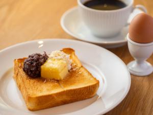 名古屋hotel androoms Nagoya Fushimi的一块白板,上面有一块烤面包,上面有奶酪和一杯咖啡