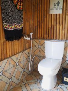 特特巴图Tetebatu Hostel的一间白色厕所,浴室内有管道