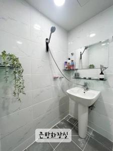 釜山Narae House的带淋浴和盥洗盆的白色浴室