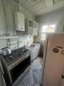 波韦尼尔Cabañas 644的厨房配有炉灶、水槽和冰箱。