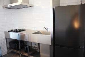 淡路Hotel Dios - Vacation STAY 40406v的厨房配有水槽和黑冰箱。
