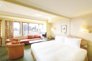 北九州Art Hotel Kokura New Tagawa的酒店客房,配有床和沙发