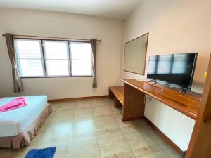 涛岛Lotus Hostel Beach Koh Tao的一间卧室配有一张床和一台平面电视