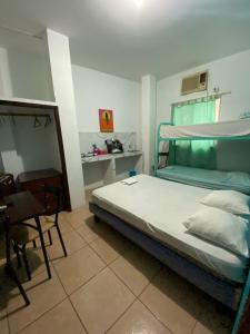 曼塔Playa Malecón, suites y Apart’s的卧室配有1张床、1张桌子和1把椅子