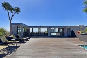 开普敦Unit 305 Cape Royale Luxury Apartments的一个带躺椅和棕榈树的甲板