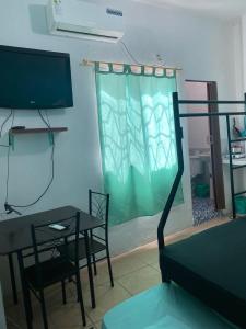 曼塔Playa Malecón, suites y Apart’s的客厅配有桌子和电视