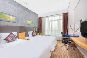 北京北京东直门智选假日酒店的酒店客房配有两张床和一张书桌