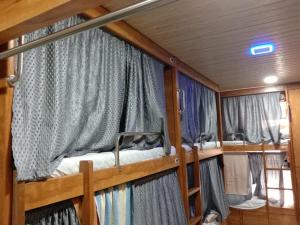 孟买Kailasha - Hostel Cum PG的带窗帘的客房内的两张双层床