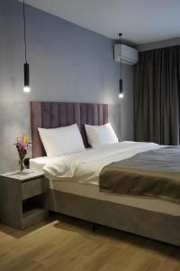 阿斯塔纳Dami Astana Hotel的卧室配有带白色枕头的大床