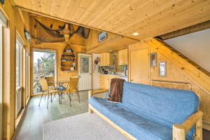 SeldoviaSerene Seldovia Cabin的一间客厅,客厅里有一个蓝色的沙发,位于一个小房子里