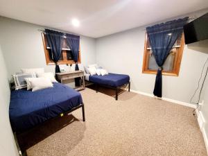 DepewSpacious Buffalo Niagara Falls Apt, Close to Buffalo Airport的一间卧室设有两张床、一张桌子和窗户。