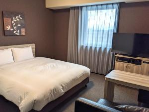 千叶HOTEL ROUTE-INN Chiba Hamano -Tokyowangan doro-的酒店客房,配有床和电视