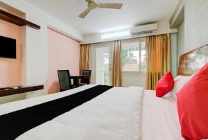 阿勒皮AEC Travel and Leisure Solution Pvt Ltd的卧室配有带红色枕头的大型白色床
